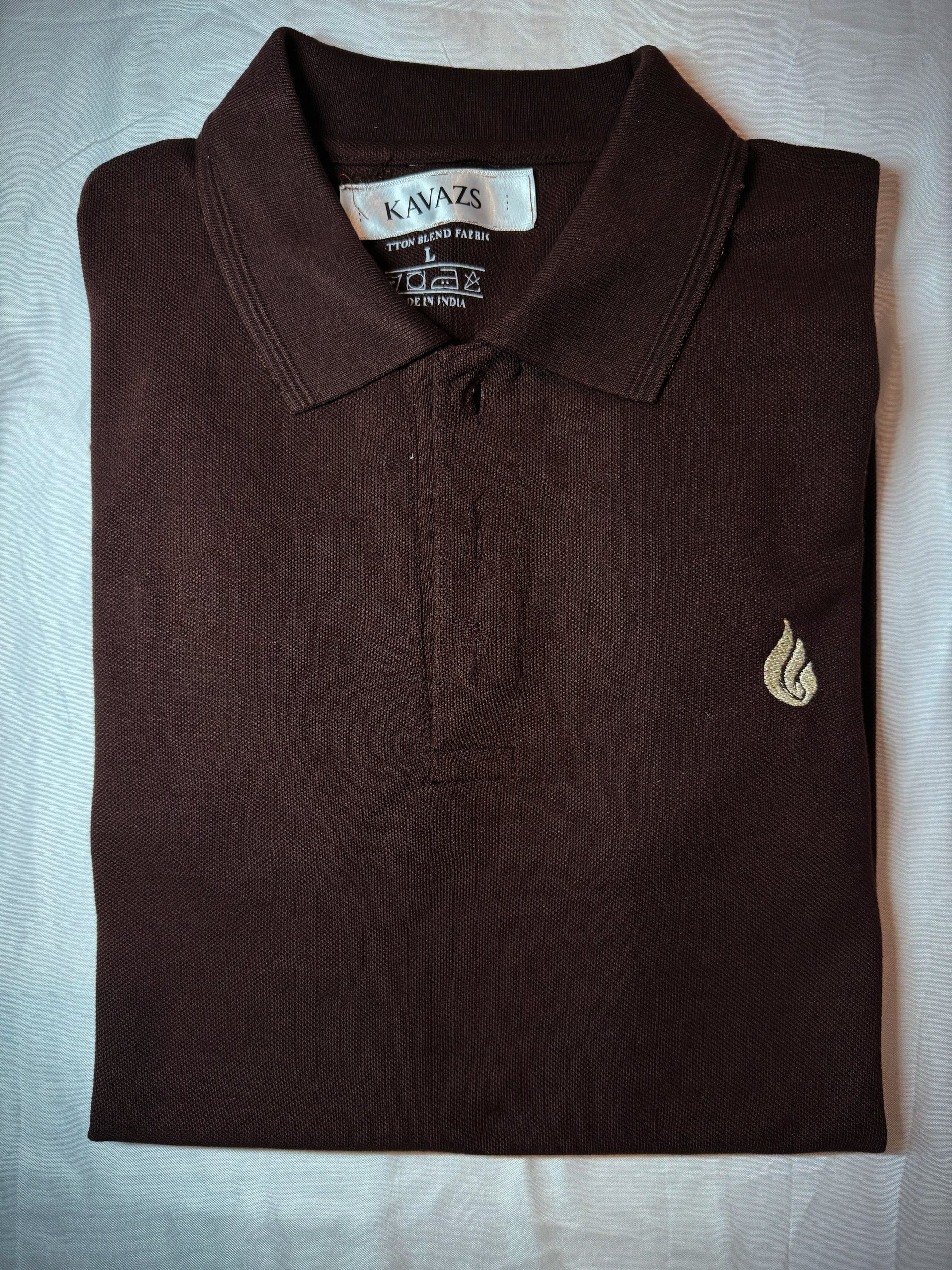 Folded brown polo shirt with a kavazs logo on a light gray background